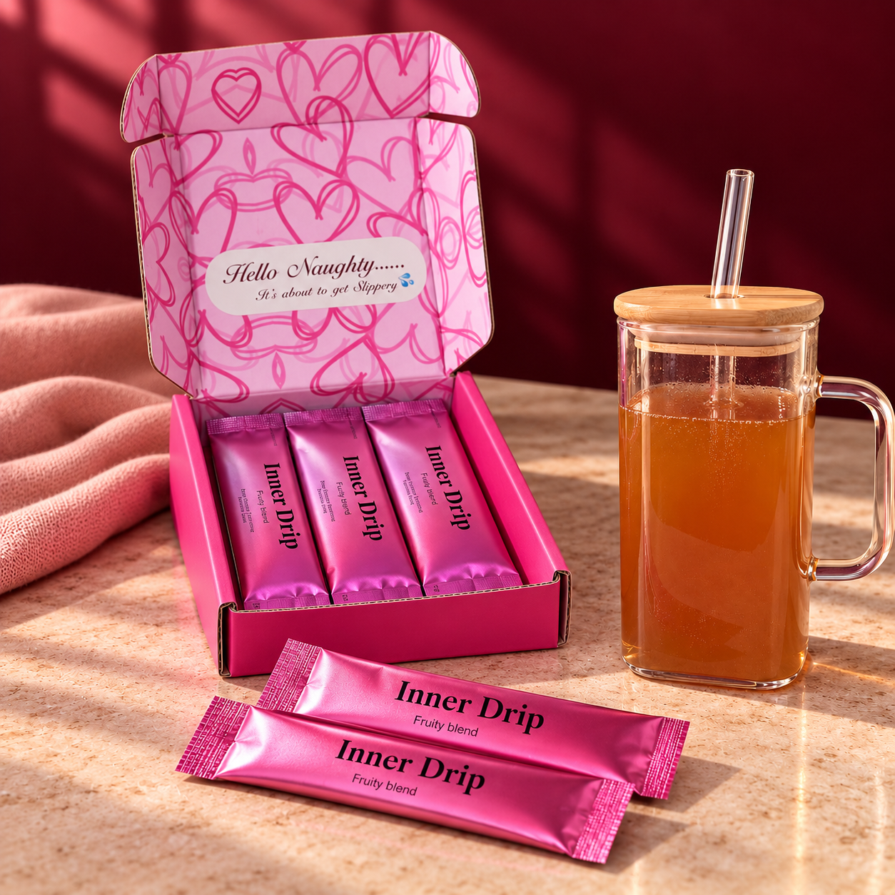 InnerDrip pink box and sachets beside a glass of amber-brown prepared drink